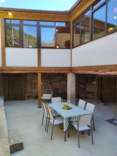 a patio with a table and chairs in a building at Casa Rural Xures Lobios in Pereira