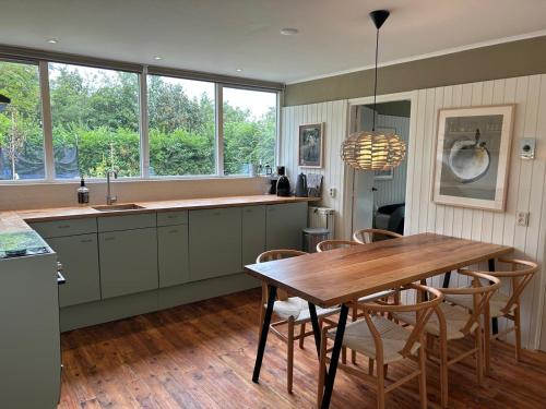 Una cocina con una mesa de madera y un comedor. en Beach Hangout Hygge, en Den Burg