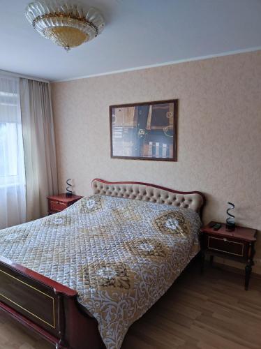 a bedroom with a bed and two night tables at Apartamentai šalia parko in Šiauliai