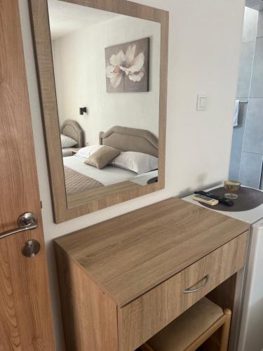 a bathroom with a mirror and a bed in a room at Apartmani Juković in Ulcinj