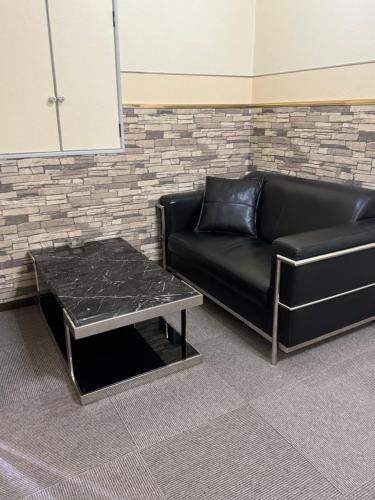 a black couch and a coffee table in a room at Village lereve in Takeo