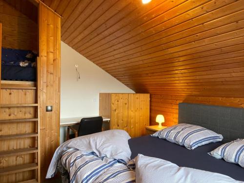 a bedroom with two beds and a wooden ceiling at Berghof Arnika in Sankt Andreasberg