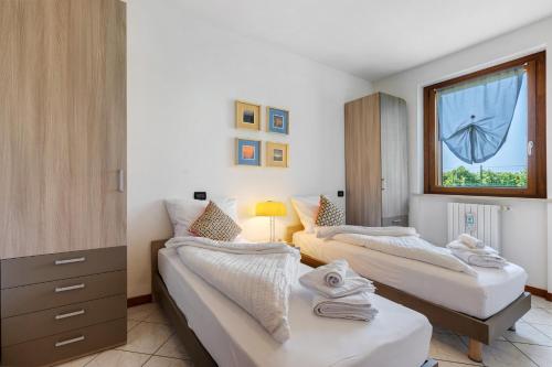 une chambre avec deux lits et une fenêtre dans l'établissement Katy Lake Lavanda, à Peschiera del Garda