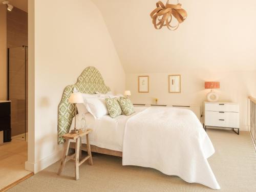 a bedroom with a white bed and a bathroom at The Old Winery Cottage No1 in Shepton Mallet