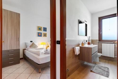 une chambre avec un lit et une salle de bain avec un lavabo dans l'établissement Katy Lake Lavanda, à Peschiera del Garda