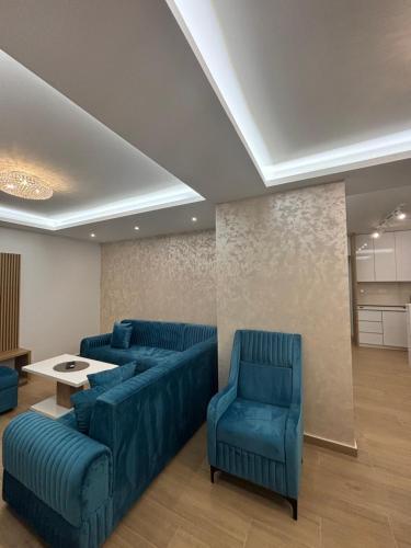 a living room with two blue couches and a table at Apartmani Milos - Meljine in Herceg-Novi