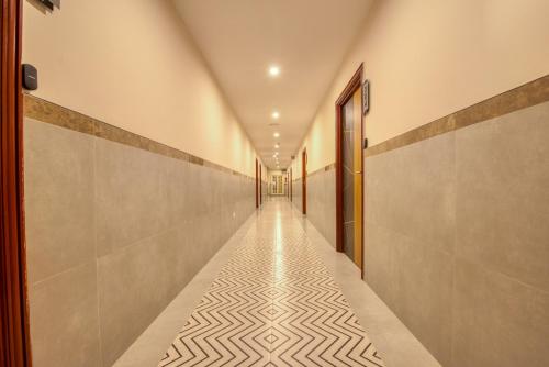 a hallway with a tile floor and a long corridor at Hotel Sunlight in Puducherry