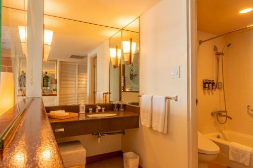 a bathroom with a sink and a toilet and a mirror at Hotel Nikko Guam in Tumon