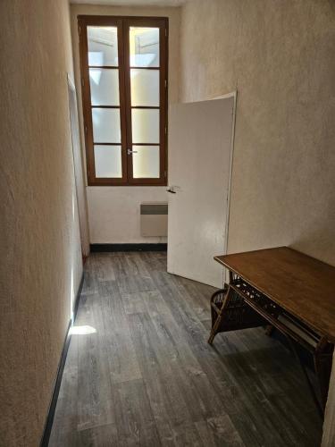 une chambre vide avec un réfrigérateur et une fenêtre dans l'établissement LIBERTE1, à Arles