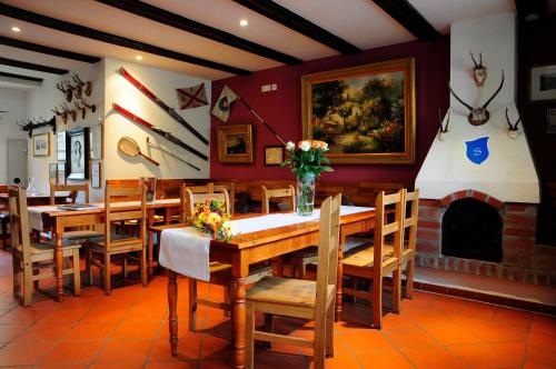 a dining room with a table and chairs and a fireplace at Hotel Schlossresidenz Heitzenhofen in Duggendorf