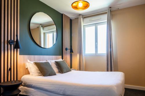 une chambre avec un grand lit et un miroir dans l'établissement Nemea Appart Hotel Green Side Biot Sophia Antipolis, à Biot