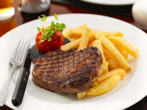 a steak and french fries on a white plate at Pennine Manor Hotel in Huddersfield