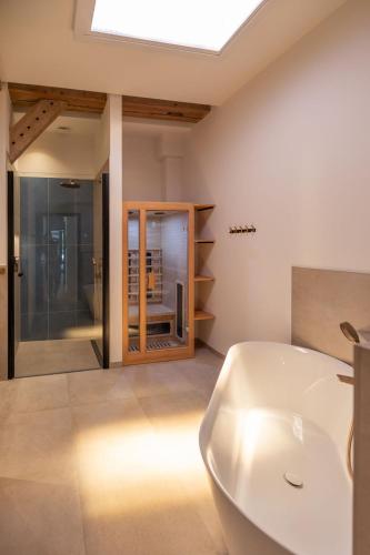 a bathroom with a white tub and a sink at Reethus 22 Loft 6 in Timmendorfer Strand