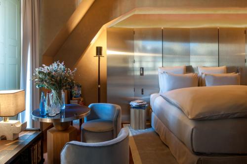 a bedroom with a bed and a table and a chair at Cour des Vosges - Evok Collection in Paris