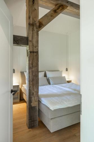 a bedroom with a large white bed with wooden beams at Reethus 22 Loft 2 in Timmendorfer Strand