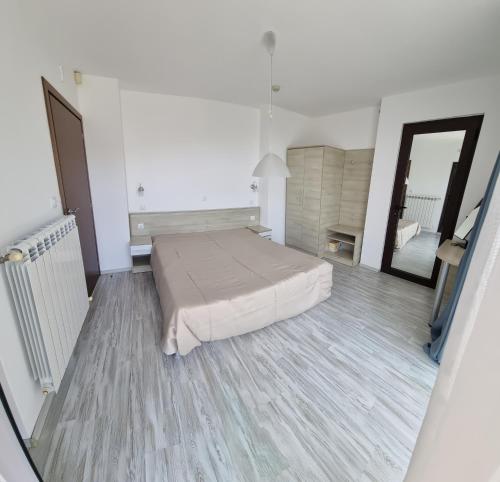 Habitación amplia con cama y espejo. en Sunny house, en Pismenovo