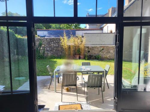 une extension en verre d'une maison avec une table et des chaises dans l'établissement Loft familial en plein cœur du Croisic, au Croisic
