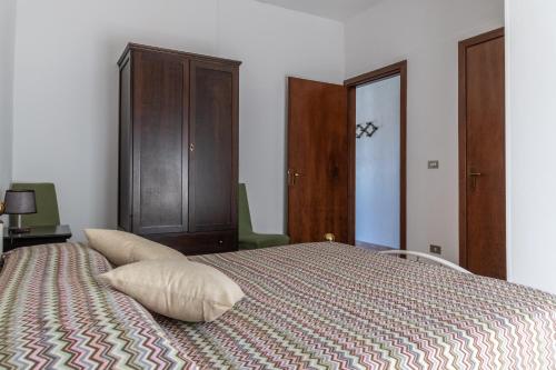 a bedroom with a bed with a wooden cabinet at La casa dei Nonni in San Giorgio Lucano