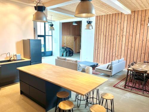 a kitchen with a table and chairs and a living room at Loft familial en plein cœur du Croisic in Le Croisic