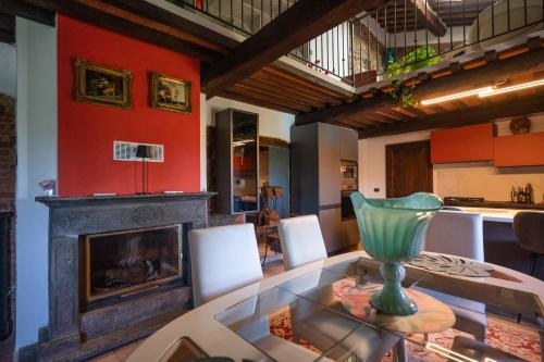 a dining room with a glass table and a fireplace at Il Casale La Duchessa in Vetulonia