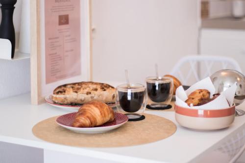 une table avec des assiettes de nourriture et des verres de vin dans l'établissement Le Boho Chic Studio Cosy, à Narbonne
