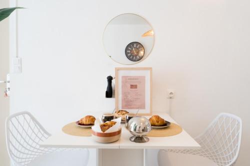 - une table avec un plateau de pâtisseries et un miroir dans l'établissement Le Boho Chic Studio Cosy, à Narbonne