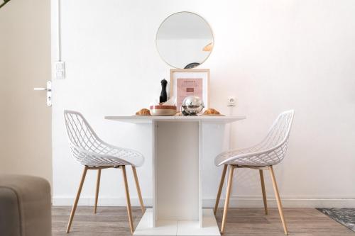 - une table avec deux chaises et un miroir dans l'établissement Le Boho Chic Studio Cosy, à Narbonne