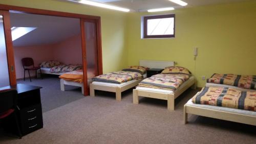 Habitación con 3 camas y espejo. en Penzion Taurus en Litomyšl