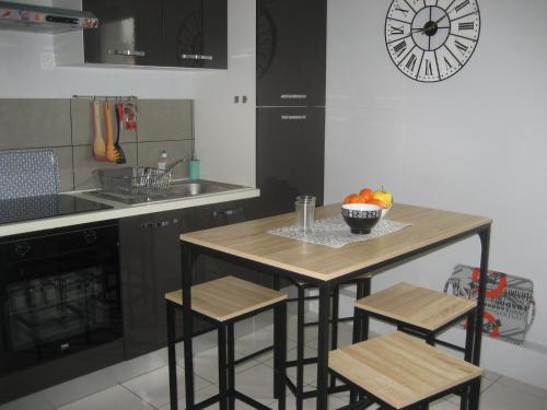 une cuisine avec une table avec un bol de fruits dessus dans l'établissement Appart agréable 2 chambres Quartier calme toutes commodités, à La Rochelle