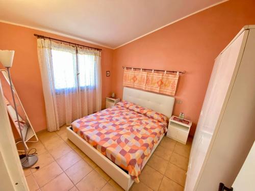 a bedroom with a bed and orange walls at Casa con giardino con climatizzatore!!! in Costa Rei