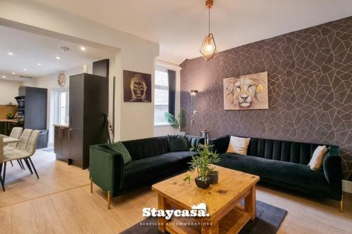 a living room with a green couch and a table at Clarence Co-living - Private Room Self-cater in Manchester