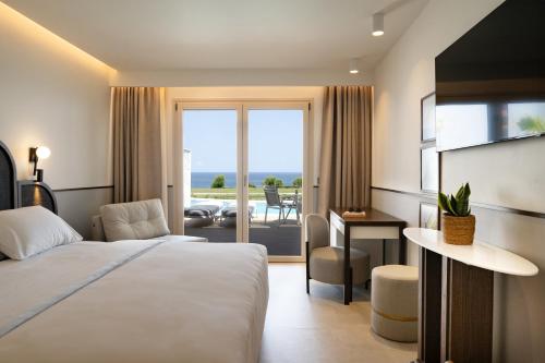 a hotel room with a bed and a view of the ocean at Iberostar Selection Creta Marine in Panormos Rethymno