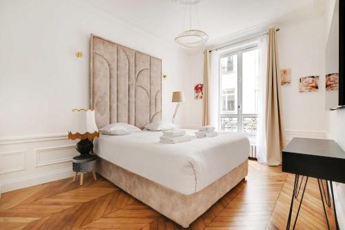 une chambre blanche avec un grand lit et une fenêtre dans l'établissement Dazzling flat - 3BD8P - Arc de Triomphe, à Paris