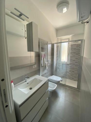 a white bathroom with a toilet and a sink at A casa di Vitto in Borghetto Santo Spirito