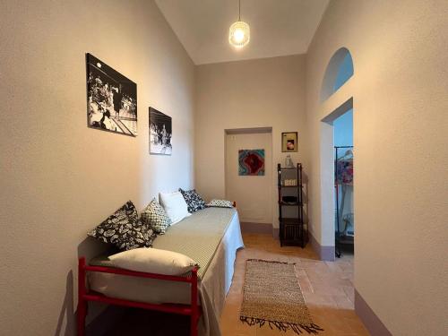 a small bedroom with a bed and a hallway at Faro Capel Rosso in Isola del Giglio