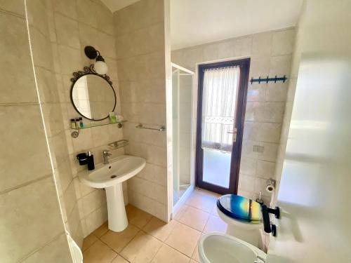 a bathroom with a toilet and a sink and a mirror at Casa con giardino con climatizzatore!!! in Costa Rei