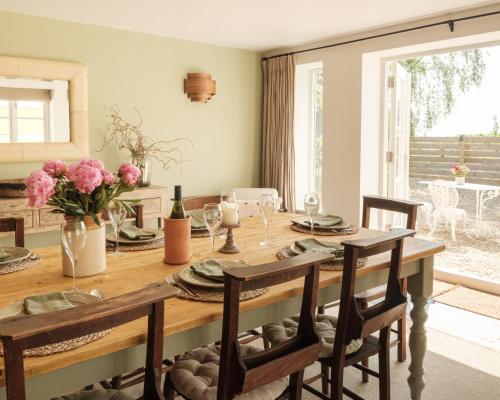 a dining room with a wooden table with chairs at Vine Cottage in Shepton Mallet