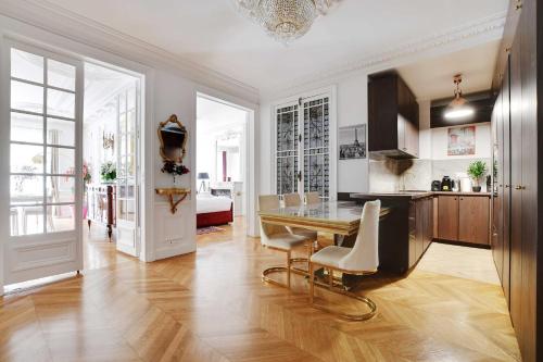 une cuisine et une salle à manger avec une table et des chaises dans l'établissement Luxurious flat - 4BD8P - Arc de Triomphe, à Paris
