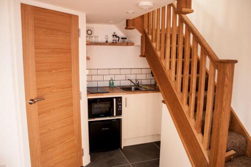 a kitchen with a staircase and a sink and a microwave at Clunie in Braemar