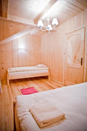 a bedroom with a bed and a bench in a room at Domki Prokop in Ciche