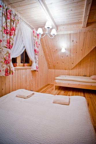 a bedroom with two beds in a wooden room at Domki Prokop in Ciche