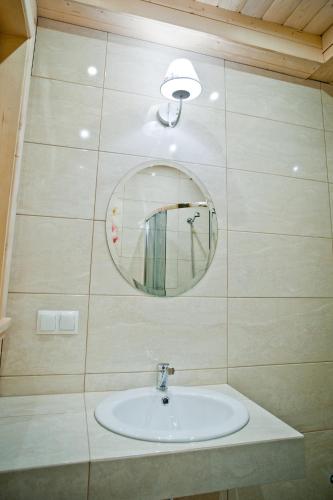 a bathroom with a sink and a mirror at Domki Prokop in Ciche