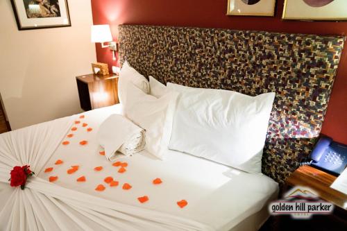 a hotel room with a bed with hearts on it at Golden Hill Parker Hotel in Elmina