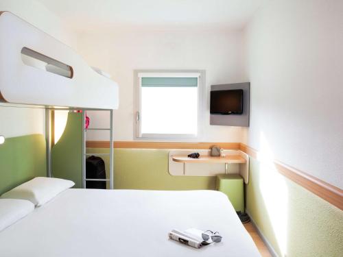 a hospital room with a bed and a tv at ibis budget Beaconsfield in Beaconsfield