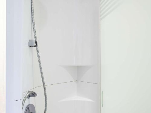 a shower with a hose in a bathroom at ibis budget Beaconsfield in Beaconsfield