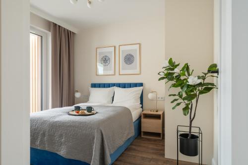 a bedroom with a bed with a tray of food on it at Rezydencja Merwede Aparthotel - My Rest in Gdańsk