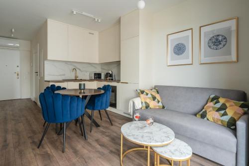 a living room with a couch and a table and chairs at Rezydencja Merwede Aparthotel - My Rest in Gdańsk
