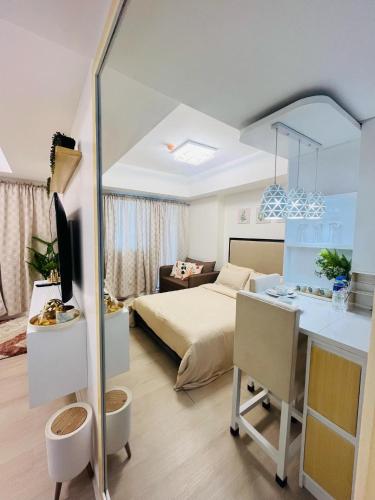 a bedroom with a bed and a desk with a desk at Azure North- Serenity Homes by J&J Condo rentals in Lagundi