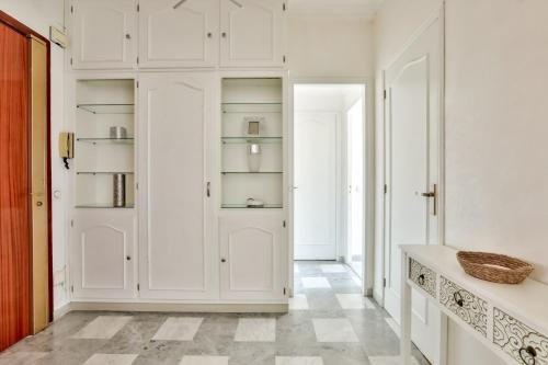 un couloir avec des armoires blanches et une porte dans l'établissement Superbe T2 avec terrasse et parking, à Nice