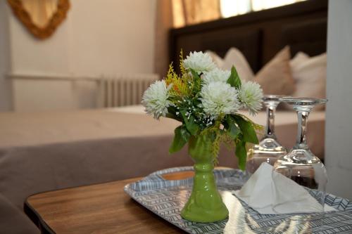 a green vase with flowers on a table at Hotel Metropol in Piteşti